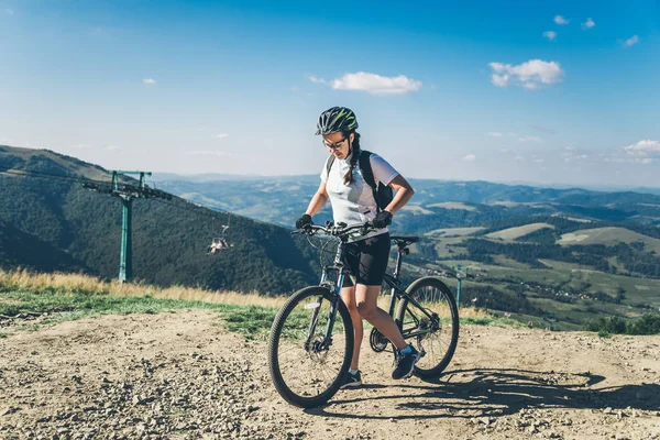 Young woman riding on MTB in mountains — Stock Photo, Image