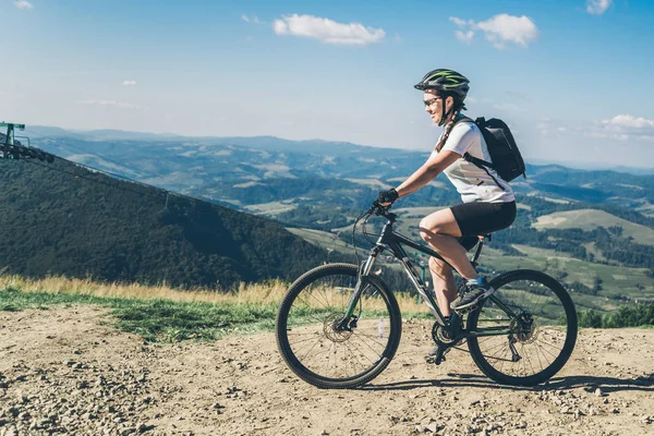 Junge Frau reitet auf MTB in den Bergen — Stockfoto