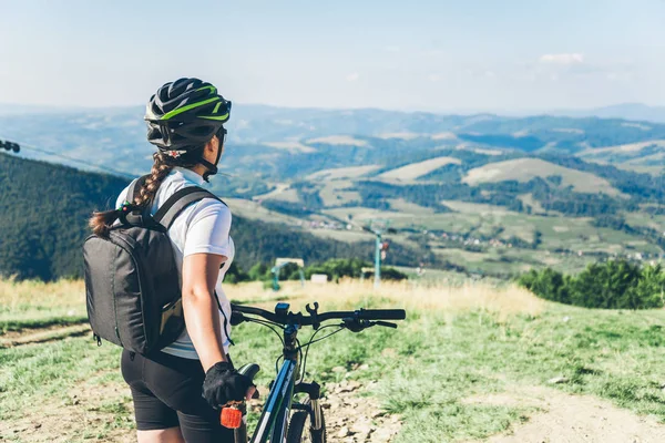 Young woman riding on MTB in mountains — Stock Photo, Image