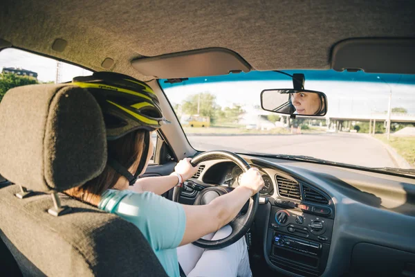 Woman driving car in helmet with horror on her face — Stock Photo, Image