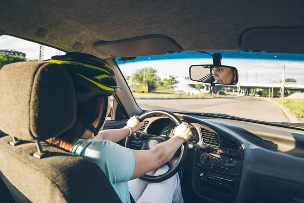 Woman driving car in helmet with horror on her face — Stock Photo, Image