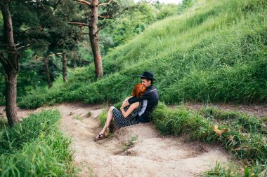 iz üzerinde dinlenme ve birbirlerine sarılma bir çift