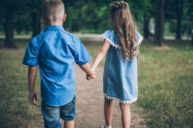 Küçük bir oğlan ve kız birlikte yürüyüş ve birbirlerine elele