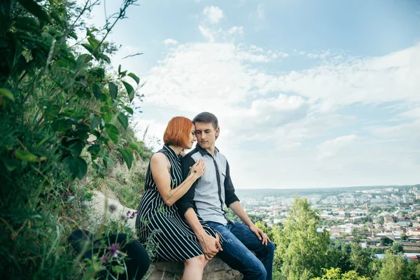 Couple sitis on the hill with ponaramic view — Stock Photo, Image