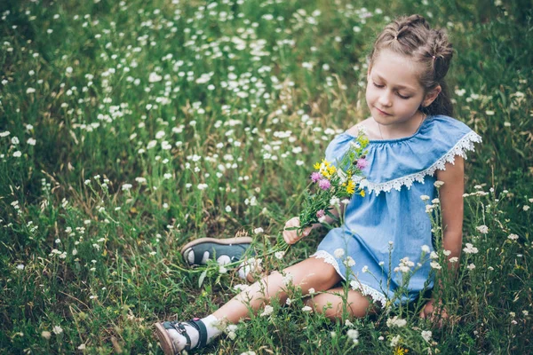 Mladá dívka smalling pole květiny — Stock fotografie