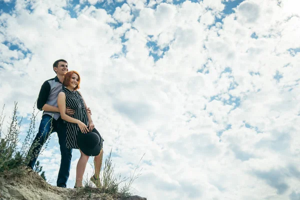 Young man with woman stands on the hill and looks straight ahead — Stock Photo, Image