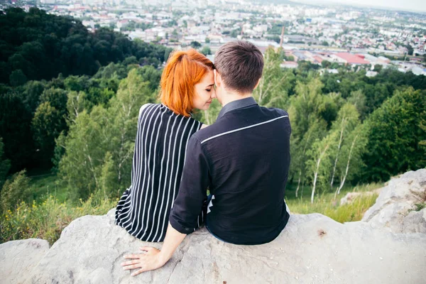 Young woman sits with her boyfriend on the peak of the hill — Stock Photo, Image
