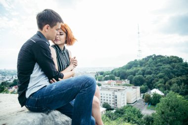 genç kadın sevgilisi ile tepenin zirvesine oturur.