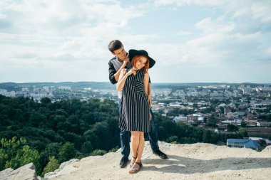 hill sarılma üzerinde duran ve şehir manzaralı seyir Çift