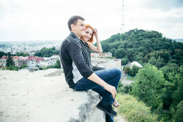 Молодая женщина сидит со своим парнем на вершине холма — стоковое фото