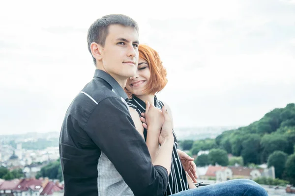 Young woman sits with her boyfriend on the peak of the hill — Stock Photo, Image