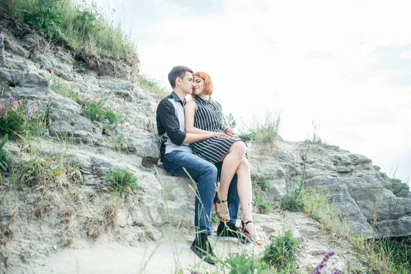 Cute couple sit on the hill and looking for the view — Stock Photo, Image