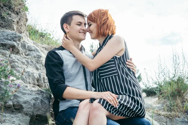 Casal bonito sentar-se na colina e à procura da vista — Fotografia de Stock