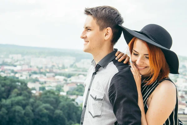Couple standing on the hill hugging and looking on city view — Stock Photo, Image