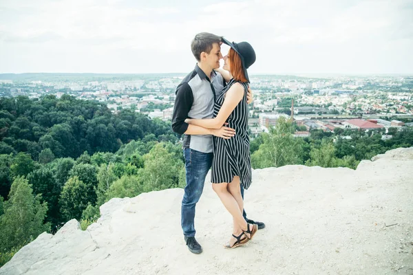 Пара, стоящая на холме обнимаясь и глядя на город — стоковое фото