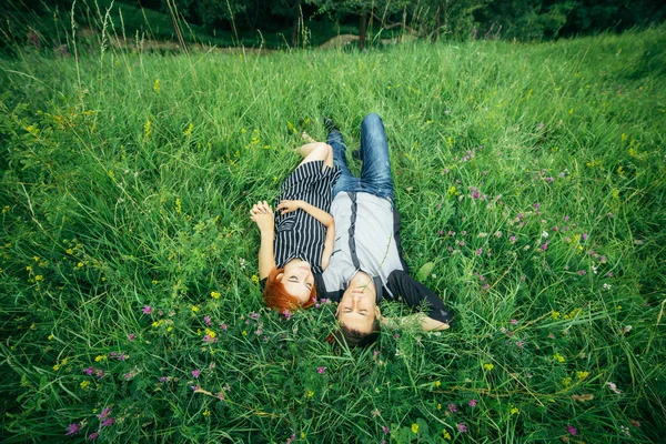 젊은 행복 한 아름 다운 커플 남녀 야외 녹색 잔디밭에는 밝은 화창한 날에 누워 — 스톡 사진