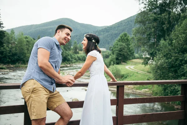 kadınla adam köprüde nehrin karşısında duruyor.