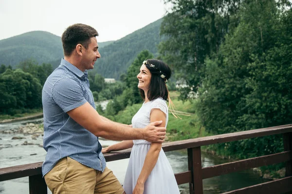 Homme avec femme se tient sur le pont à travers la rivière — Photo