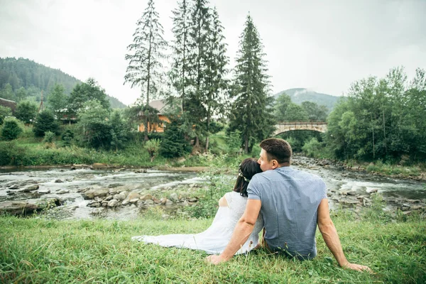 Пара сидит у горной реки — стоковое фото