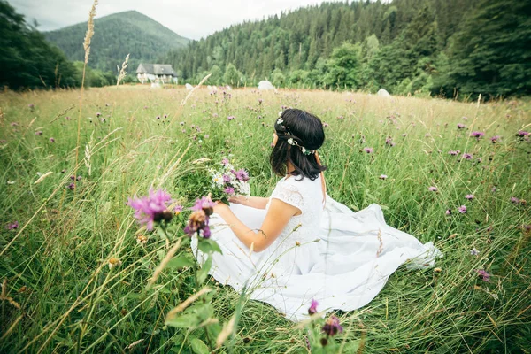 Sorrindo jovem morena no vestido sentado em — Fotografia de Stock