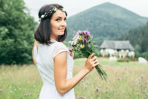 Young pretty woman portrait with flowers in mountains — Stock Photo, Image
