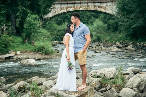 Пара стоит в передней части старого моста в горах — стоковое фото