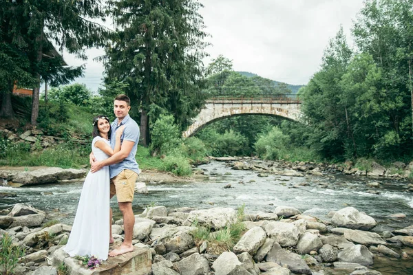 Пара стоит в передней части старого моста в горах — стоковое фото