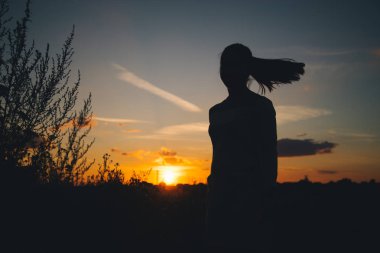 Akşam gökyüzü ile bir kadın silüeti