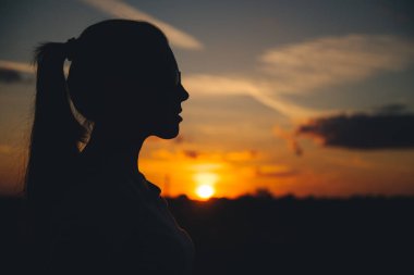 Akşam gökyüzü ile bir kadın silüeti