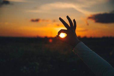 eller ok işaretini günbatımı üzerinde göster.