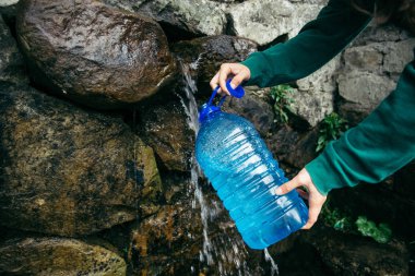 kadın el dağlar su kaynağı şişeden doldurmak