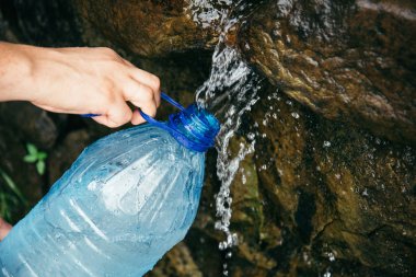 kadın el dağlar su kaynağı şişeden doldurmak