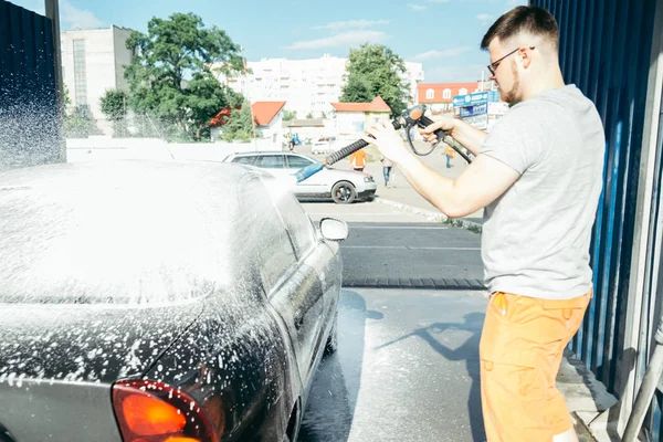 Lavado de coches a mano con una preparación de espuma para pulir, coches en un lavado de coches — Foto de Stock