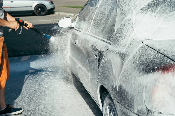 car washing by hand using a foam preparation for polishing,cars in a carwash