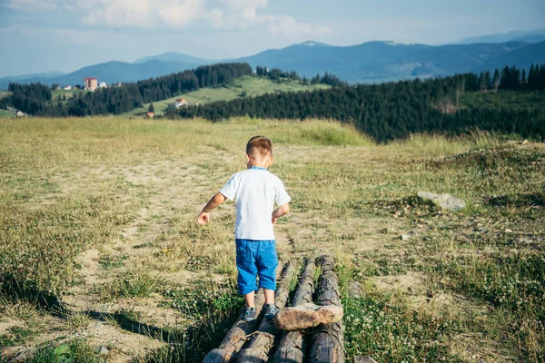 Kleiner Junge spielt auf dem Gipfel der Berge — Stockfoto