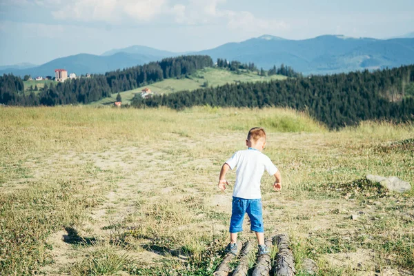 Liten pojke som spelar på toppen av bergen — Stockfoto