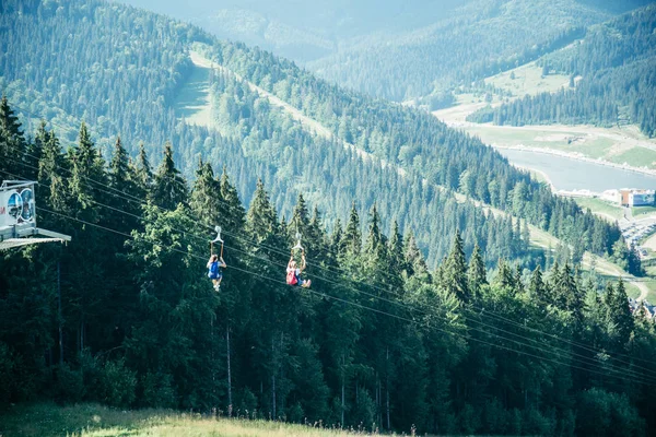Homme vol en tyrolienne dans les montagnes — Photo