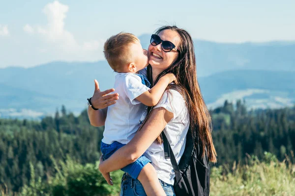 Mulher brincando com seu filho no pico da montanha — Fotografia de Stock