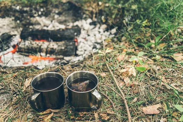 Dos tazas de metal con té cerca de la hoguera —  Fotos de Stock