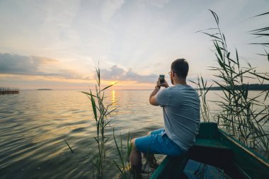 Adam alarak resim yaptığı telefon eski tekne otururken Sunrise