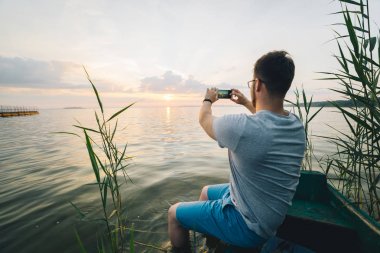 Adam alarak resim yaptığı telefon eski tekne otururken Sunrise