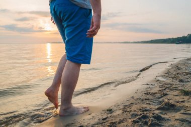 kum deniz kenarında yürüyen adam