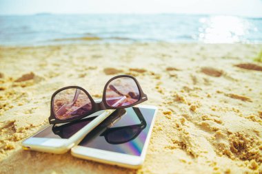 güneş gözlüğü ile sahilde iki telefonlar