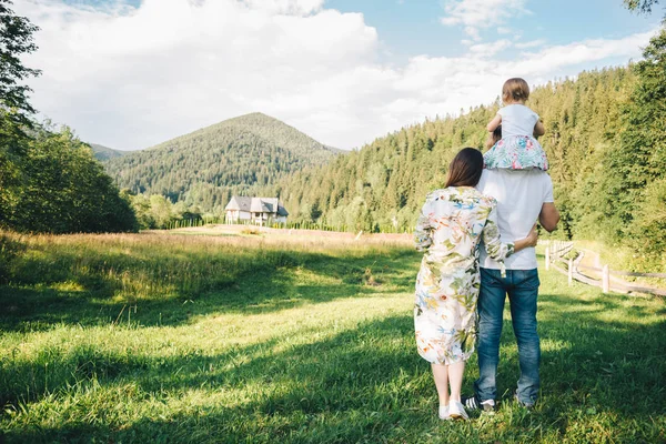 Padres juegan con hija en el campo con montañas en el fondo —  Fotos de Stock