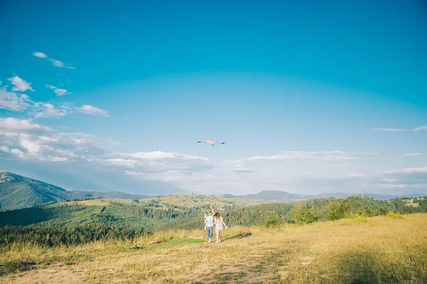 Familjen som löper genom området låta kite flyger — Stockfoto