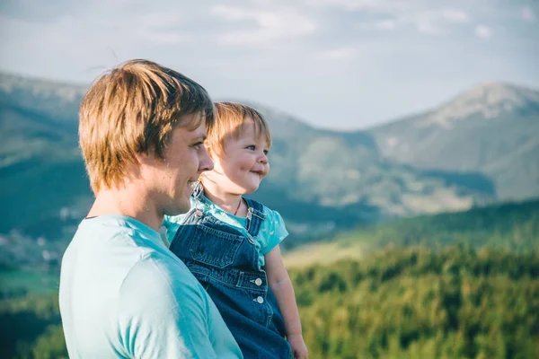 Pai e filha em suas mãos no topo das montanhas — Fotografia de Stock