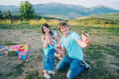 uçurtma ile oynarken mutlu genç aile alarak selfie