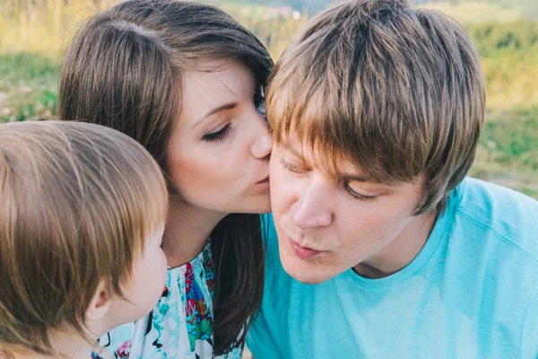 Madre beso padre en mejilla delante de hija —  Fotos de Stock