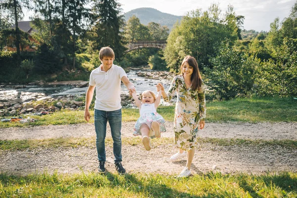 Jovem família plaing com sua filha em montanhas — Fotografia de Stock