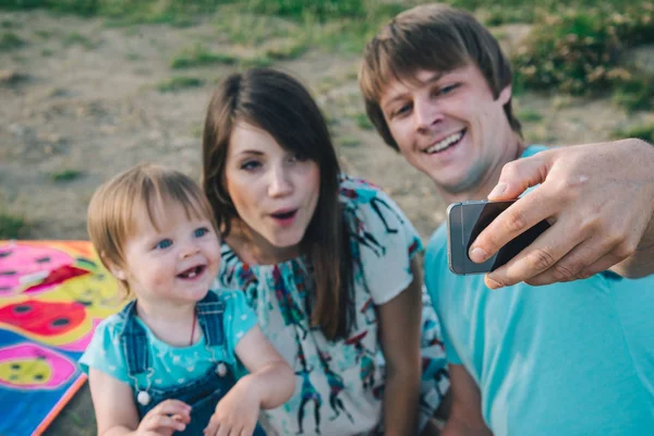 Feliz joven familia tomando selfie mientras jugando con cometa —  Fotos de Stock